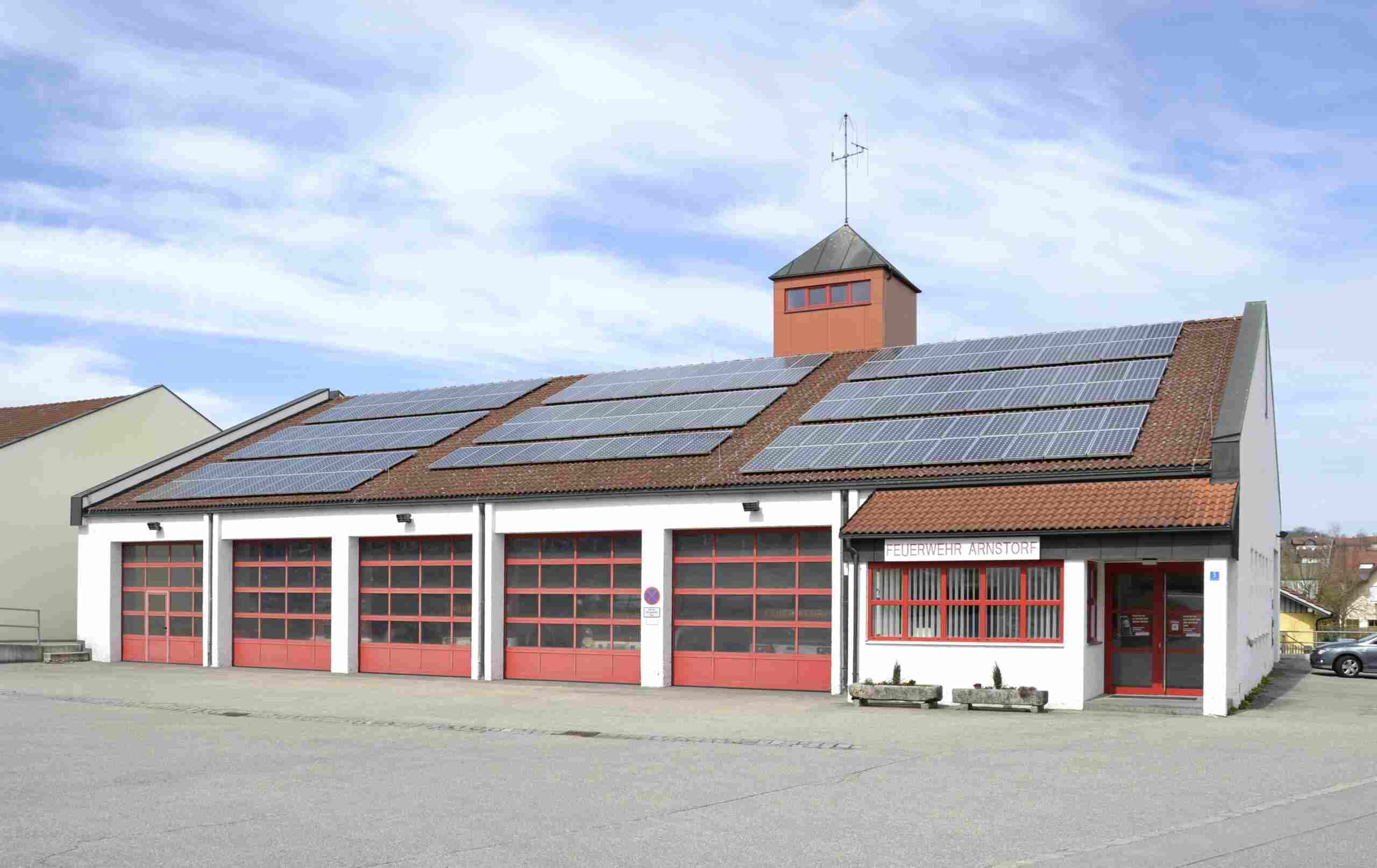 Feuerwehrhaus mit roten Toren und Solarmodulen in Arnstorf, Bayern, fotografiert 2012. Beispielaufnahme, nicht die geplante Feuerwache Gießen-Mitte.